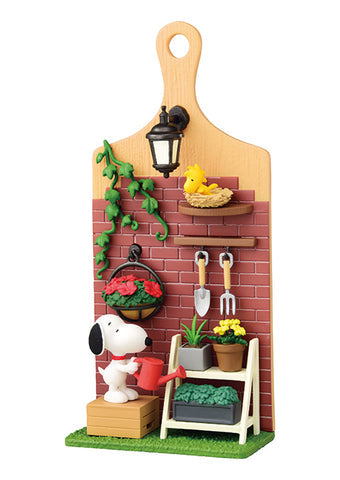 Garden-themed playset with Snoopy watering plants against a brick wall.