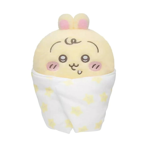 Plush toy resembling a cartoon character wrapped in a blanket with yellow polka dots on a white background