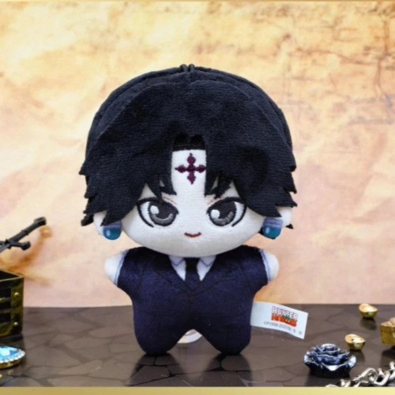 Plush toy with black hair and white face on a reflective surface with a beige background