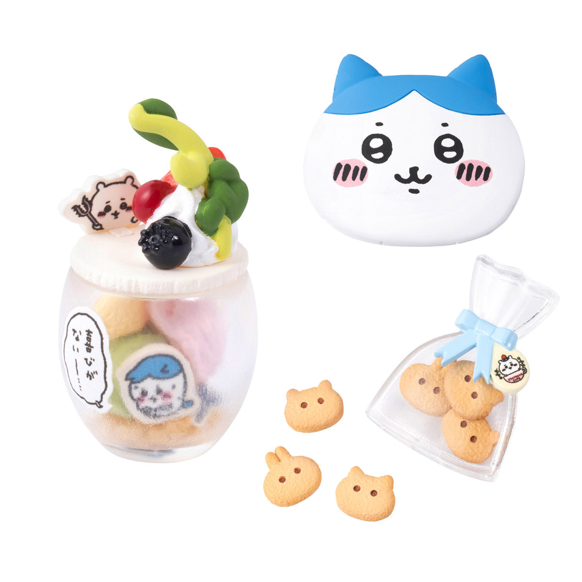 Set of cat-themed cookies and a glass with a cat design on a white background