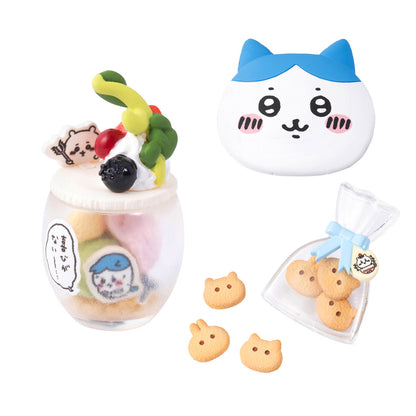 Set of cat-themed cookies and a glass with a cat design on a white background