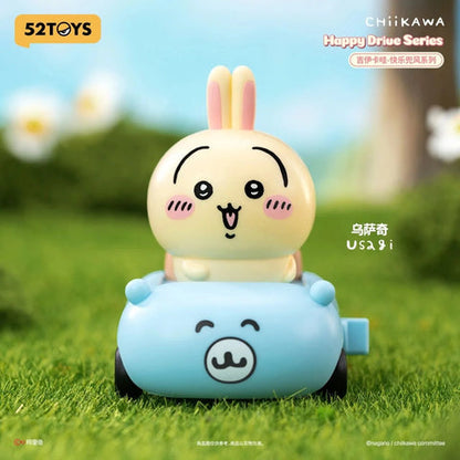 52TOYS Chiikawa Happy Drive Series blind box display showing Chiikawa, Hachiware, and Usagi driving colorful pull-back miniature cars with pink packaging.