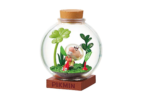 Glass style terrarium with a character and plants on a wooden base, featuring the ' Pikmin' brand.