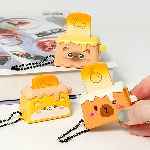 Bread Pops Up Toaster Keychain — miniature toaster bag charm with bread popping up, kawaii novelty keychain