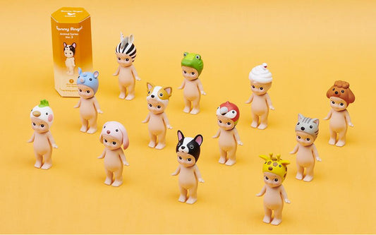 Set of baby figurines with animal hats on a yellow background