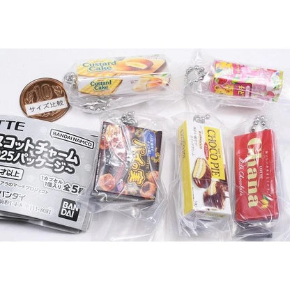 Bandai Lotte Mascot Charm 2025 Package Gashapon collection featuring miniature keychains of Custard Cake, Koala's March, Pai no Mi, Choco Pie, and Ghana Milk Chocolate.